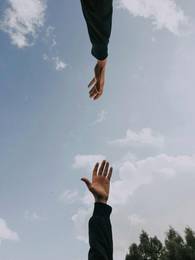 Hand streckt sich nach anderer aus